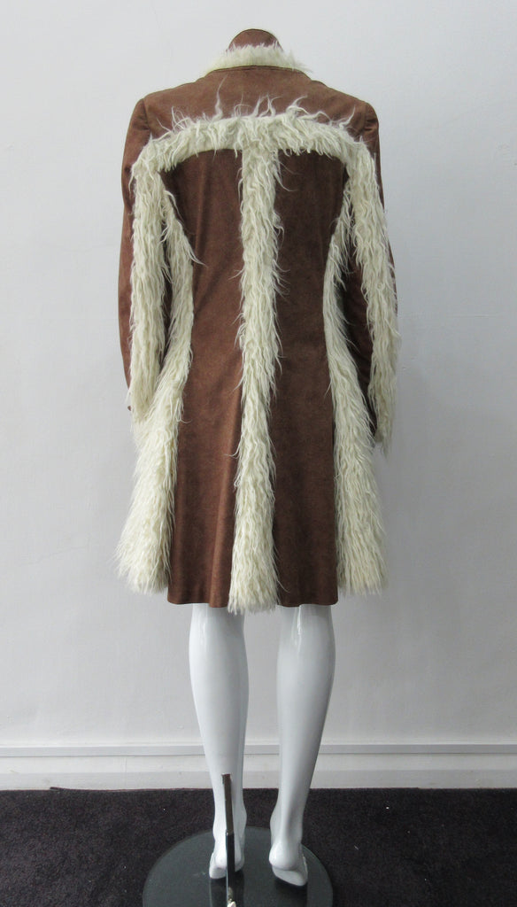 Split Suede Coat. Faux suede coat with faux fur contrast trim on lapels and inside. Flared towards hem with contrast faux fur panels. Rich saddle lighter brown colour. Feminine version inspired from 18th century men's evening coat. Multiple ways of buttoning as illustrated. Can be paired with 060301 Brown Suede Trouser. Formerly a showpiece, specially made. No Label. CB Length 94cm. Sleeve length from side shoulder point 75cm. 850g approximate weight. 95% Polyester, 5% Rayon. Contrast: 100% Viscose. Dry Cl