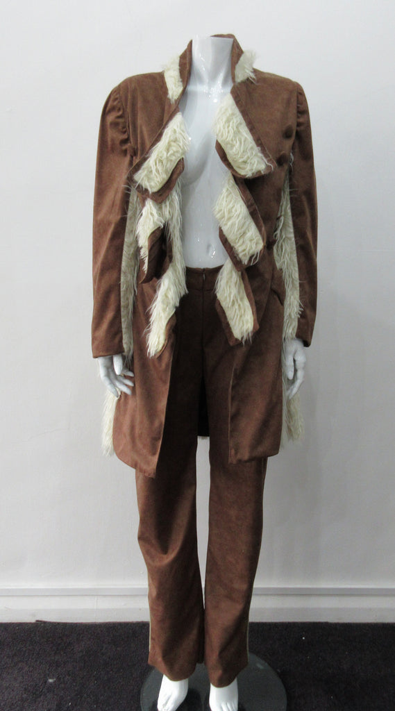Brown Faux Suede Trouser. Nicely tailored medium brown faux suede trousers with beige contrast piping. Front angle invisible zip pockets. Can be paired with 060218 Split Suede Coat. Formerly a showpiece, specially made. Inseam 83cm. Outseam 103cm. 400g approximate weight. 95% Polyester, 5% Nylon. Dry Clean Only. Made in Canada