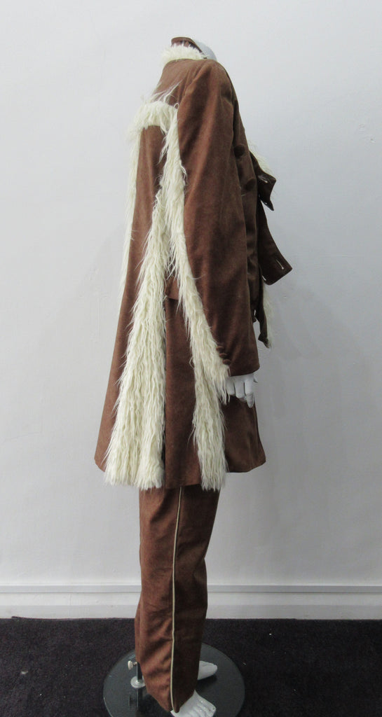 Brown Faux Suede Trouser. Nicely tailored medium brown faux suede trousers with beige contrast piping. Front angle invisible zip pockets. Can be paired with 060218 Split Suede Coat. Formerly a showpiece, specially made. Inseam 83cm. Outseam 103cm. 400g approximate weight. 95% Polyester, 5% Nylon. Dry Clean Only. Made in Canada