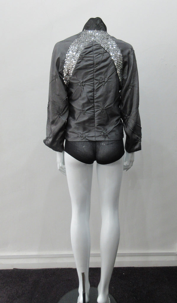 Grey Sparkle Raglan Panel Zip Jacket. Featuring pinched satin fabric and brilliant sequin panel on both front and back sides. CF zipper and 8cm high contrast collar. CB length 56cm. Sleeve length from side neck point 66cm. 220g approximate weight. 60% Polyester, 30% Viscose, 10% Nylon. Lining: 100% Rayon. Dry Clean Only. Made in Canada