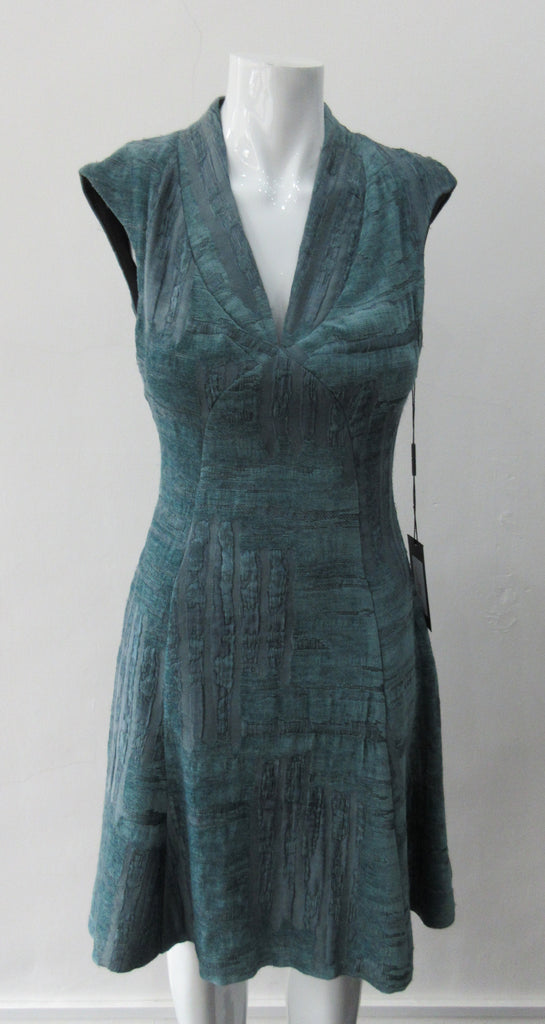 Round Seam Dress. Dark sea green textured dress with curved neck panels. With CB zipper. CB length 93cm. 82% Wool, 18% Nylon. Lining: 100% Rayon. Dry Clean Only, Made in Croatia