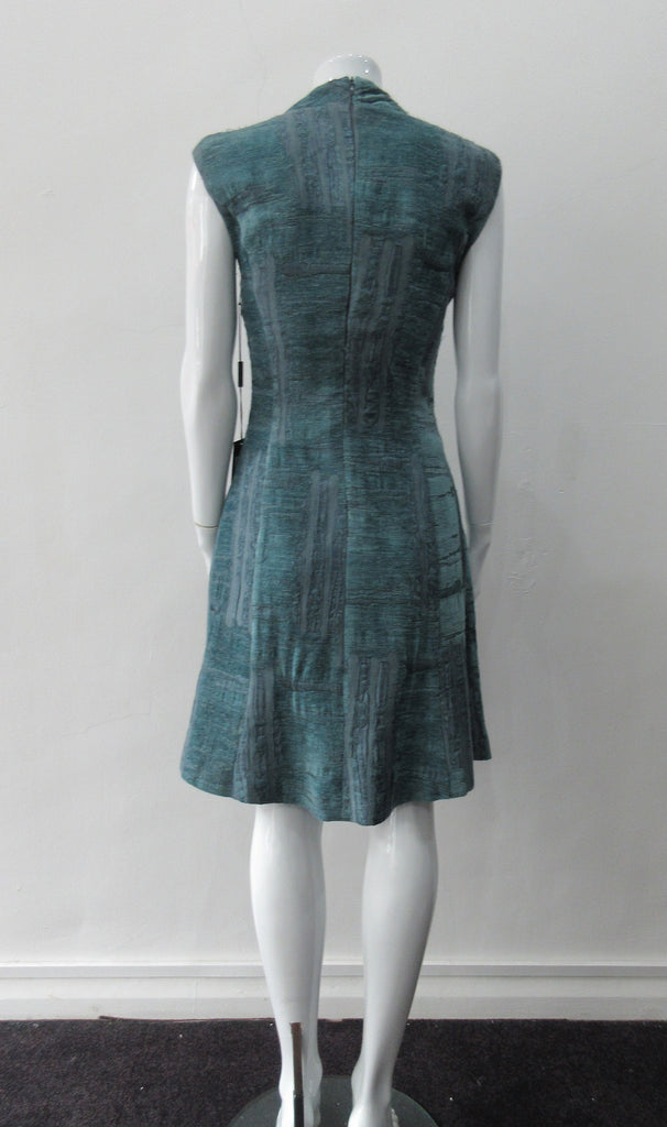 Round Seam Dress. Dark sea green textured dress with curved neck panels. With CB zipper. CB length 93cm. 82% Wool, 18% Nylon. Lining: 100% Rayon. Dry Clean Only, Made in Croatia