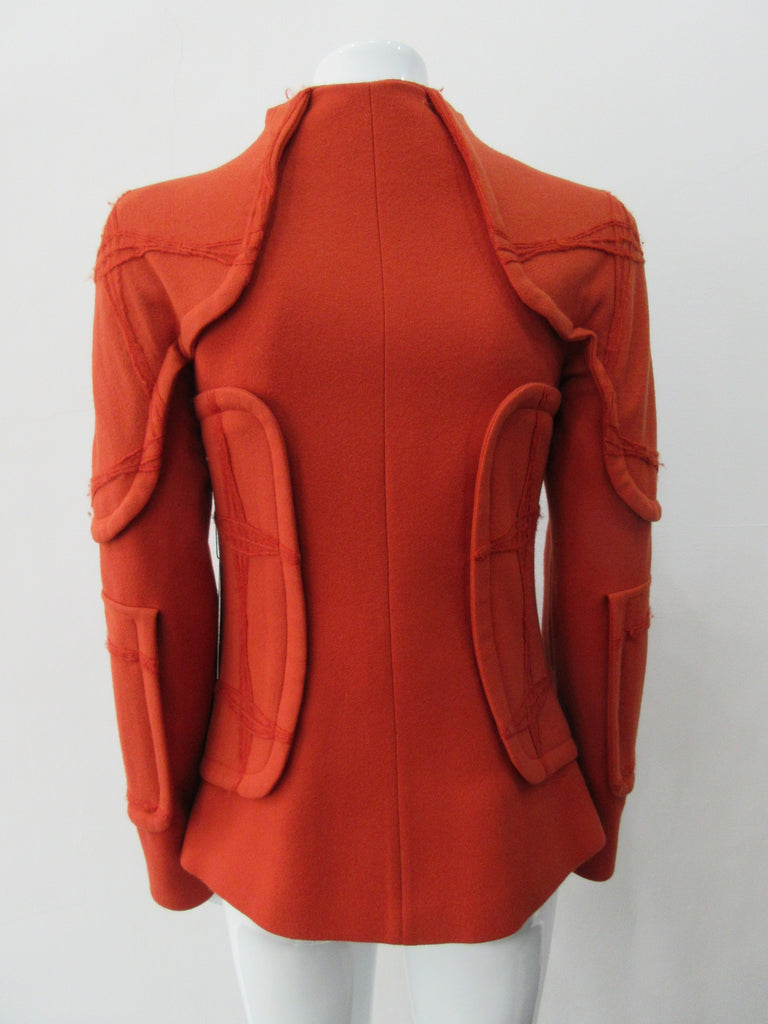 Trench Panel style Jacket in Deep Carrot Orange colour. Panel design on shoulders and side waist in Deep Carrot Orange colour. Geoetric thread design becomes more fuzzy with aging, natural process and part of the design. CF zipper. 65cm approximate length. 600g approximate weight. Size 6, 80% Wool, 20% Nylon Lining: 100% Rayon Dry Clean Only. Made in Croatia