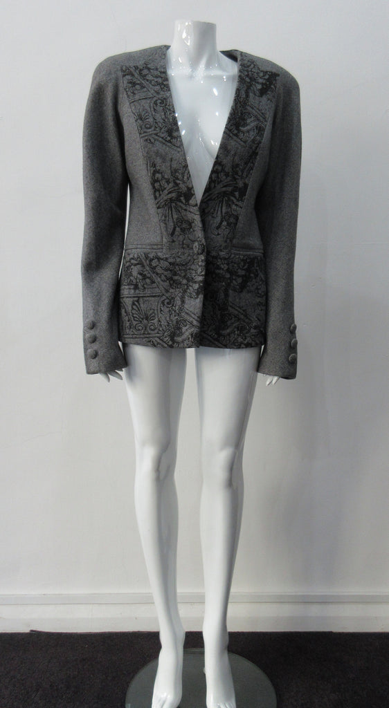 False Peak Jacket. Old-School Jacket in charcoal grey with rounded shoulders. Design features sewn in collar and lapel. Covered buttons throughout. Relaxed fit. Size 8