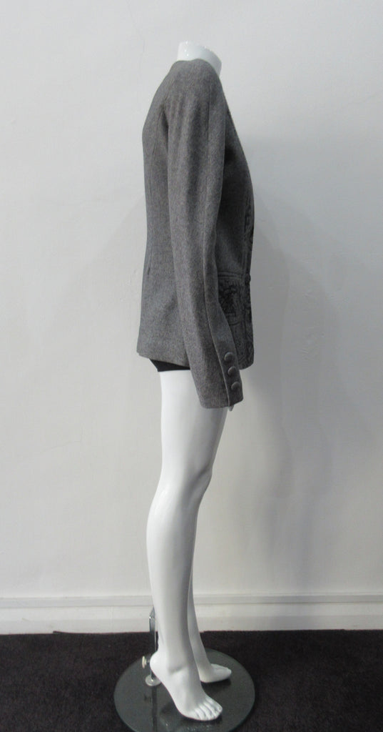 False Peak Jacket. Old-School Jacket in charcoal grey with rounded shoulders. Design features sewn in collar and lapel. Covered buttons throughout. Relaxed fit. Size 8