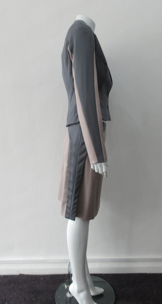 Cropped Point Sleeve Jacket. Pointed peak collared cropped style in grey with light taupe/rose contrast sleeve panels. Relaxed fit with soft raglan sleeves. Shown with matching skirt. Size 8. 100% Wool. Lining: 100% Rayon, Dry Clean Only. Made in England