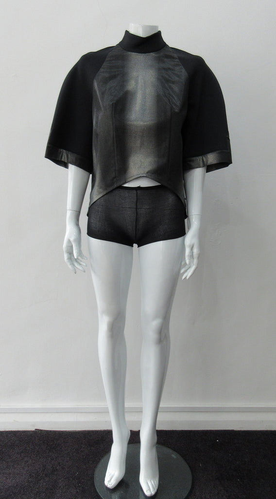 Black Crop Top. Cropped raglan sleeve top in medium weight scuba with contast charcoal colour, shiny fabric front. Medium sleeves with charcoal shiny contrast trim on sleeve hems. 5cm high collar. CB invisible zipper. CB neck point length 57cm 350g approximate weight. 85% Polyamide, 15% Elastine. Contrast: 98% Nylon, 2% Lycra. Dry Clean Only. Made in England