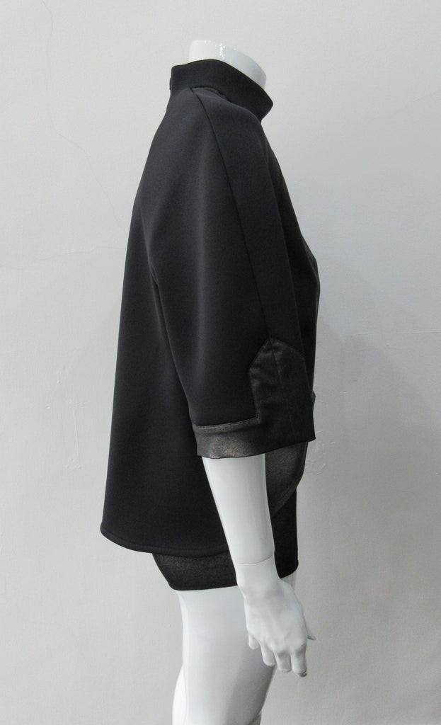 Black Crop Top. Cropped raglan sleeve top in medium weight scuba with contast charcoal colour, shiny fabric front. Medium sleeves with charcoal shiny contrast trim on sleeve hems. 5cm high collar. CB invisible zipper. CB neck point length 57cm 350g approximate weight. 85% Polyamide, 15% Elastine. Contrast: 98% Nylon, 2% Lycra. Dry Clean Only. Made in England