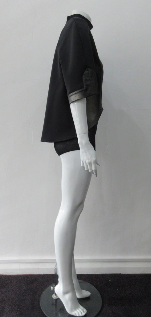 Black Crop Top. Cropped raglan sleeve top in medium weight scuba with contast charcoal colour, shiny fabric front. Medium sleeves with charcoal shiny contrast trim on sleeve hems. 5cm high collar. CB invisible zipper. CB neck point length 57cm 350g approximate weight. 85% Polyamide, 15% Elastine. Contrast: 98% Nylon, 2% Lycra. Dry Clean Only. Made in England