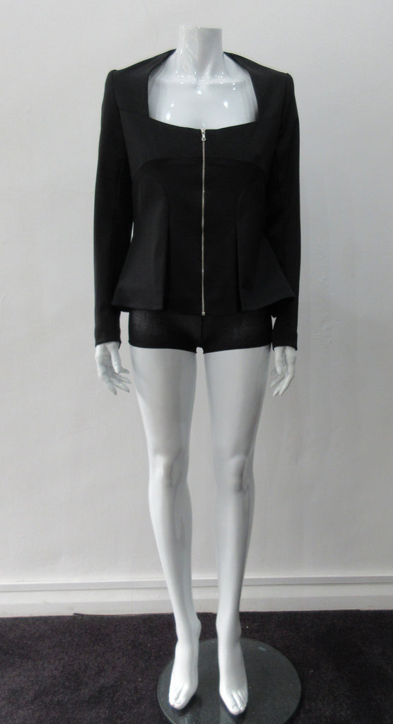 Dark Corset Jacket. Geometric cut lower front metal zip jacket with flared peplum-style hem in medium length. Designed for a tighter fit around the bust area. In solid black with slight stretch. CB length 63cm. Sleeve length from side neck point 78cm. 750g approximate weight. 95% Polyester, 5% Spandex Lining: 100% Viscose. Dry Clean Only. Made in England