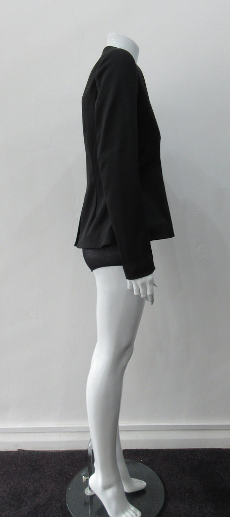 Dark Corset Jacket. Geometric cut lower front metal zip jacket with flared peplum-style hem in medium length. Designed for a tighter fit around the bust area. In solid black with slight stretch. CB length 63cm. Sleeve length from side neck point 78cm. 750g approximate weight. 95% Polyester, 5% Spandex Lining: 100% Viscose. Dry Clean Only. Made in England