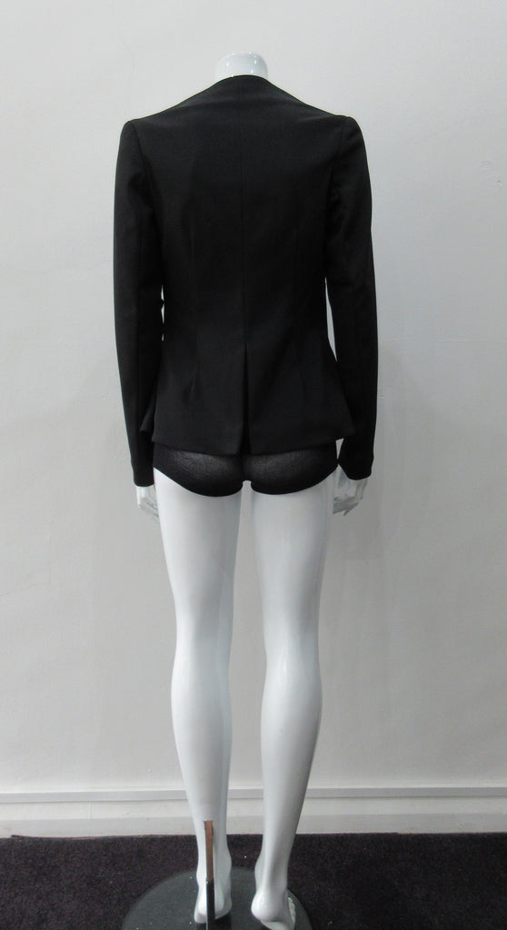 Dark Corset Jacket. Geometric cut lower front metal zip jacket with flared peplum-style hem in medium length. Designed for a tighter fit around the bust area. In solid black with slight stretch. CB length 63cm. Sleeve length from side neck point 78cm. 750g approximate weight. 95% Polyester, 5% Spandex Lining: 100% Viscose. Dry Clean Only. Made in England