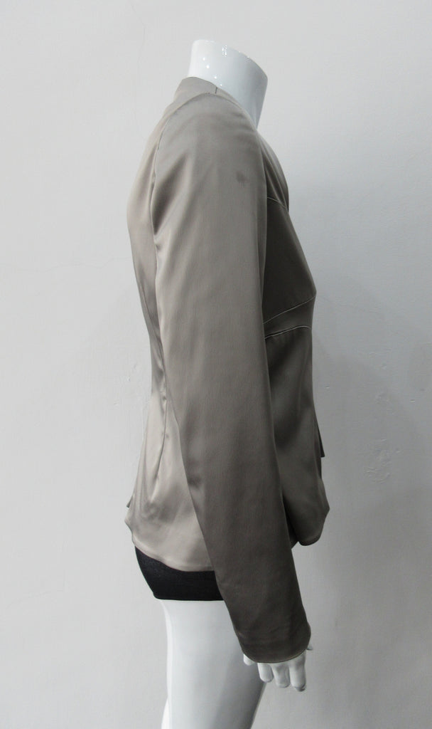 Corset Jacket. Geometric cut lower front metal zip jacket with flared peplum-style hem in medium length. Designed for a tighter fit around the bust area. In solid silver taupe colour with slight stretch. CB length 63cm. Sleeve length from side neck point 78cm. 750g approximate weight. 95% Polyester, 5% Spandex. Lining: 100% Viscose. Dry Clean Only. Made in England