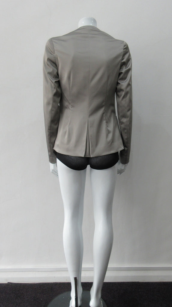 Corset Jacket. Geometric cut lower front metal zip jacket with flared peplum-style hem in medium length. Designed for a tighter fit around the bust area. In solid silver taupe colour with slight stretch. CB length 63cm. Sleeve length from side neck point 78cm. 750g approximate weight. 95% Polyester, 5% Spandex. Lining: 100% Viscose. Dry Clean Only. Made in England