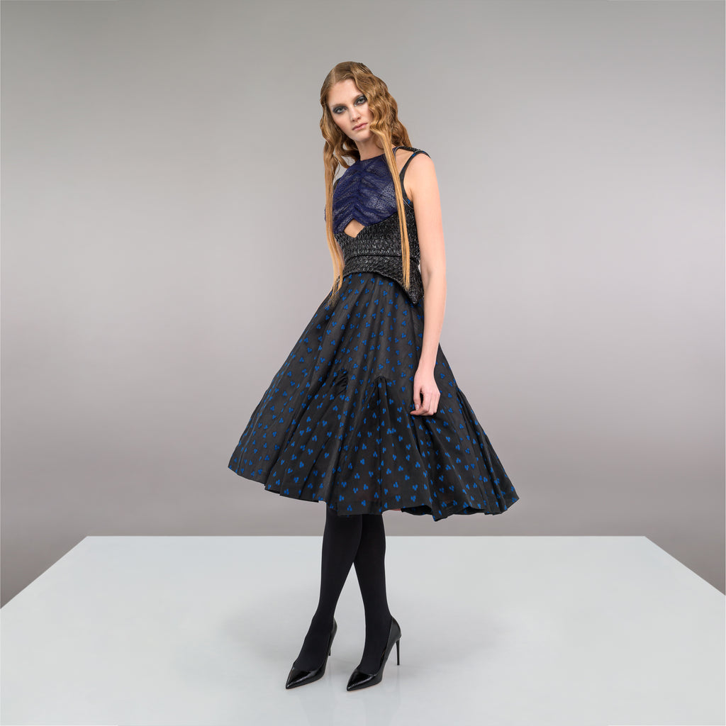 Sleevelss dress combination of blue ruched bust area with black faux leather thin peplum aspect and mid-waist panel. Gathered flounces on lower dress adds volume and greater movement. Small gap in middle of bust. 650g approximate weight. 81% Polyester, 14% Polyamide, 5% Elastine. Contrast 48% Polyester, 34% Cotton, 18% Nylon. Dry Clean Only. Made in England