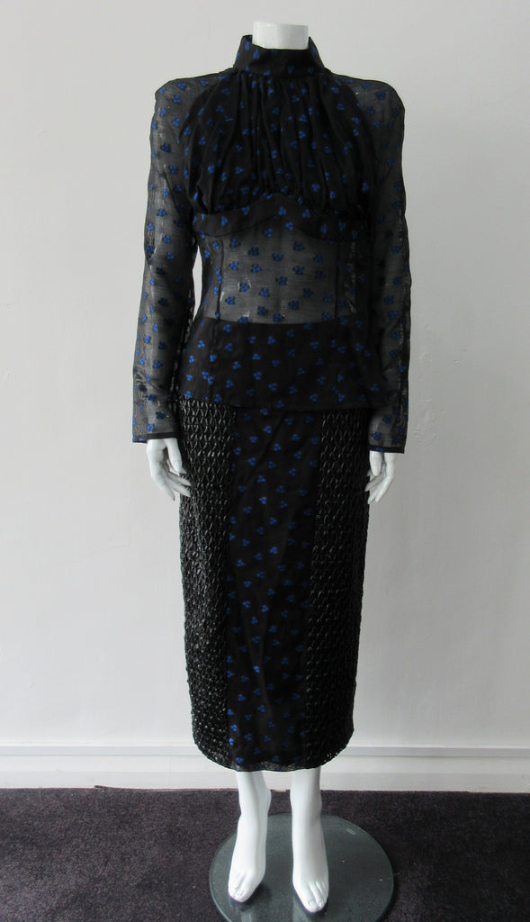 Dark Gathered Top, Generously gathered long sleve top in sheer black with tri-blue dot design. CB zipper and under bust panel trim. 2 invisible side zippers at side seam bottom. Can be paired with 180608D Dark Curve Front Pencil Skirt, CB length 60cm. 50g approximate weight 48% Polyester, 34% Cotton, 18% Nylon. Dry Clean Only. Made in England