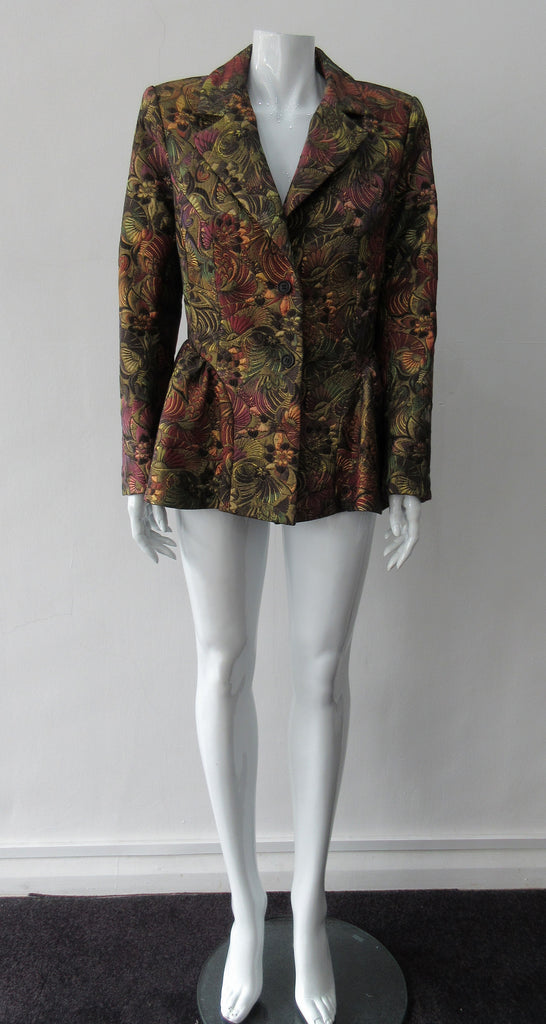 Sahara Jacket. Brass red and purlple textured brocade jacket featuring side hip gathers and 2 button front clousure. CB Length from neck point 67cm. 65% Cotton, 36% Polyester. Lining: 100% Rayon. Dry Clean Only. Made in England