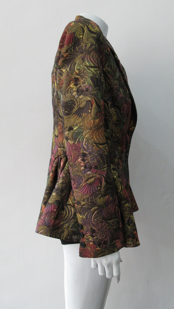 Sahara Jacket. Brass red and purlple textured brocade jacket featuring side hip gathers and 2 button front clousure. CB Length from neck point 67cm. 65% Cotton, 36% Polyester. Lining: 100% Rayon. Dry Clean Only. Made in England