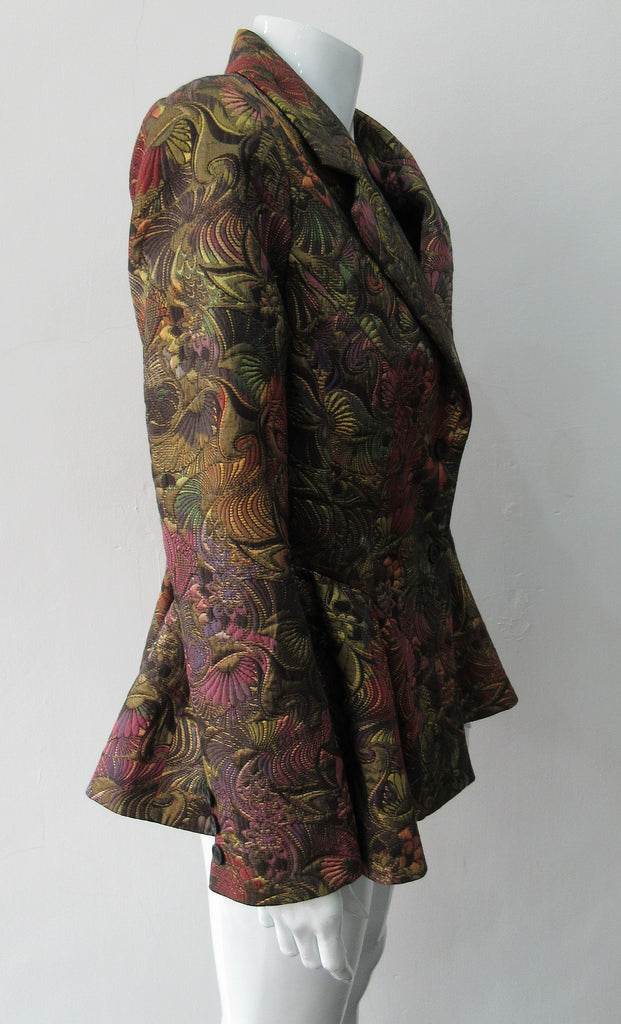 Sahara Jacket. Brass red and purlple textured brocade jacket featuring side hip gathers and 2 button front clousure. CB Length from neck point 67cm. 65% Cotton, 36% Polyester. Lining: 100% Rayon. Dry Clean Only. Made in England