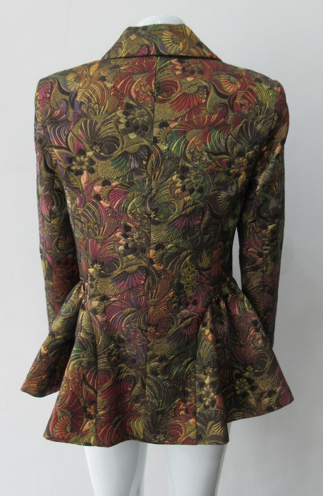 Sahara Jacket. Brass red and purlple textured brocade jacket featuring side hip gathers and 2 button front clousure. CB Length from neck point 67cm. 65% Cotton, 36% Polyester. Lining: 100% Rayon. Dry Clean Only. Made in England