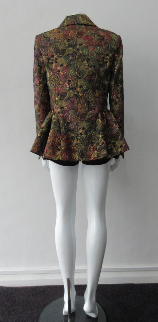 Sahara Jacket. Brass red and purlple textured brocade jacket featuring side hip gathers and 2 button front clousure. CB Length from neck point 67cm. 65% Cotton, 36% Polyester. Lining: 100% Rayon. Dry Clean Only. Made in England