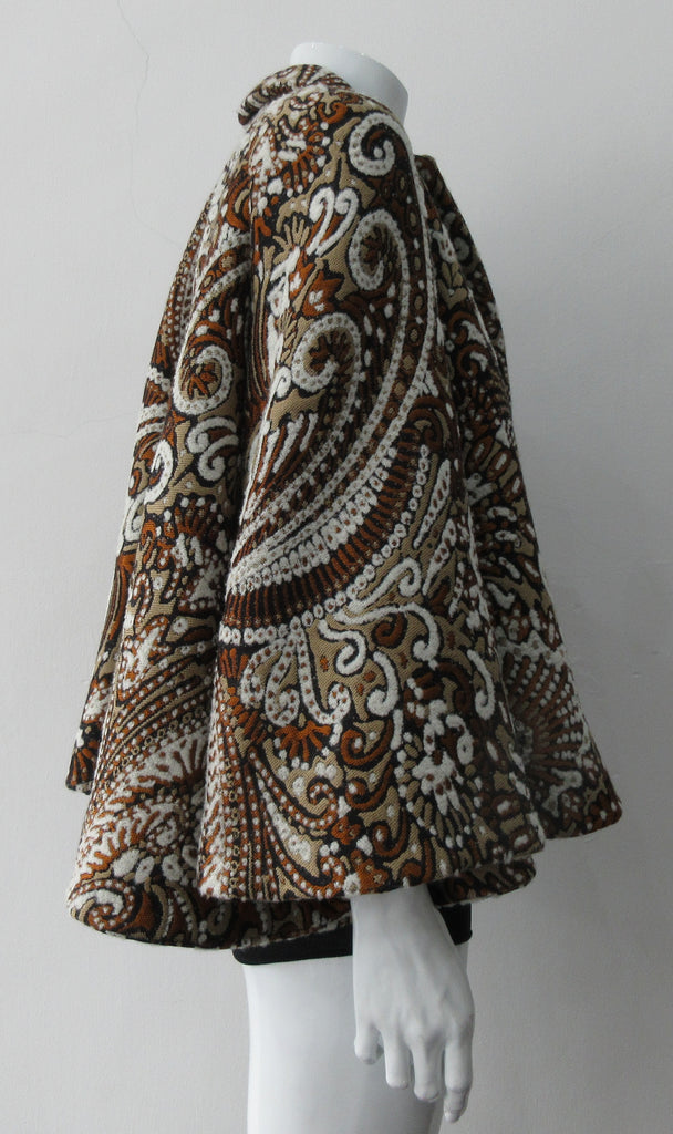 Duster Mini Swing Jacket. Cropped full swing brown, brass and beige multi textured brocade jacket. Including 2 beautiful buttons. CB length 55cm. 1.2kg approximate weight. 71% Wool, 12% Cotton, 10% Acetate, 7% Polyamide. Lining 100% Rayon. Dry Clean Only. Made in England