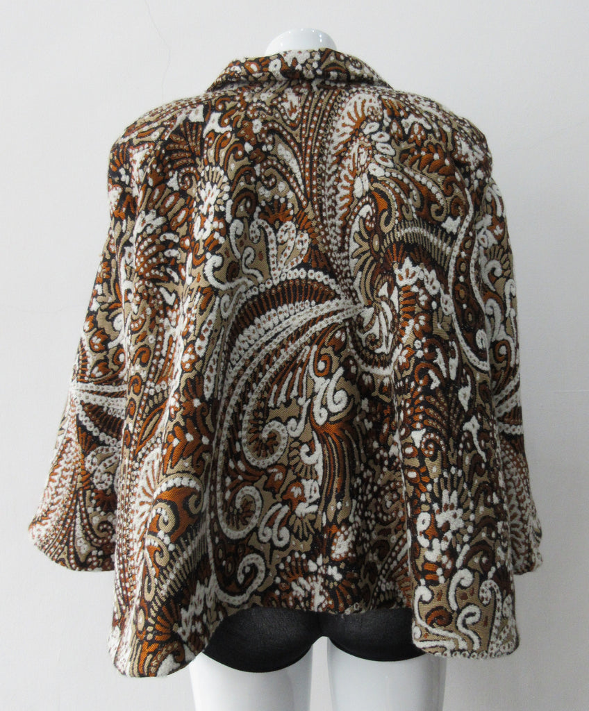 Duster Mini Swing Jacket. Cropped full swing brown, brass and beige multi textured brocade jacket. Including 2 beautiful buttons. CB length 55cm. 1.2kg approximate weight. 71% Wool, 12% Cotton, 10% Acetate, 7% Polyamide. Lining 100% Rayon. Dry Clean Only. Made in England