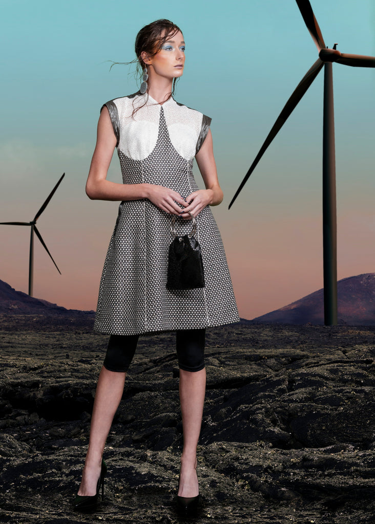 Swing Dress. Mixed array of black & white cross tooth with sheer chunky knit upper bodice, and grey Tyvek shoulder & arm panel. Contrast piping on front & back seams. CB length from neckpoint 96cm. 110g approximate weight. 86% Cotton, 14% Nylon. Contrast: 100% Acrylic. Lining: 100% Rayon. Dry Clean Only.Made in England