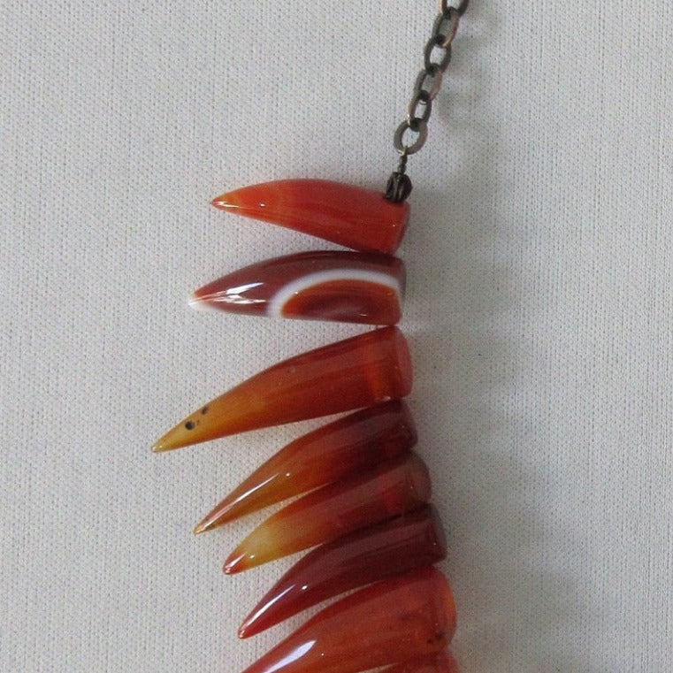 Tiger tooth pointed crystals in deep and blood orange colours. Smooth texture.