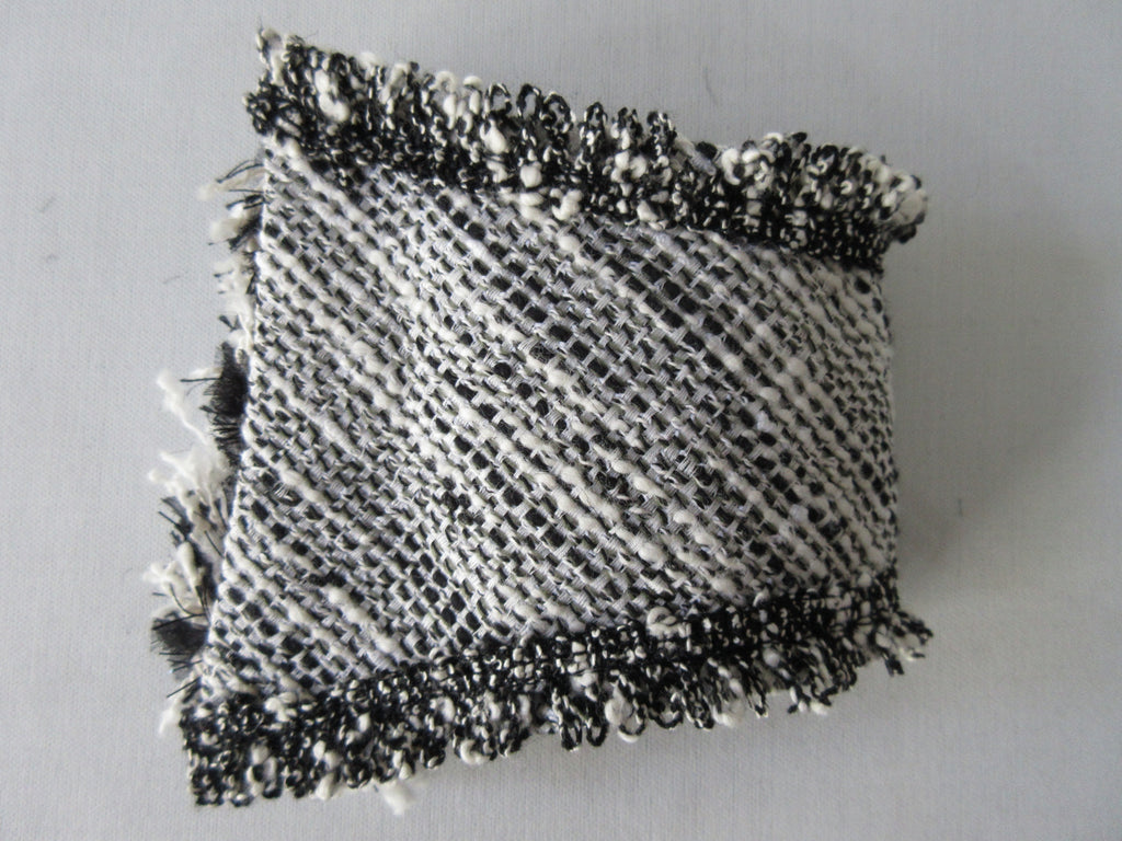 Black & White Tweed style weave, with frayed detail on edge, 100% wool with 100% Cotton inner back lining. Snap Closure. Size M -17cm from snap to snap width Size L -18cm from snap to snap width. 60g approximate weight, comes in white box. Made in France