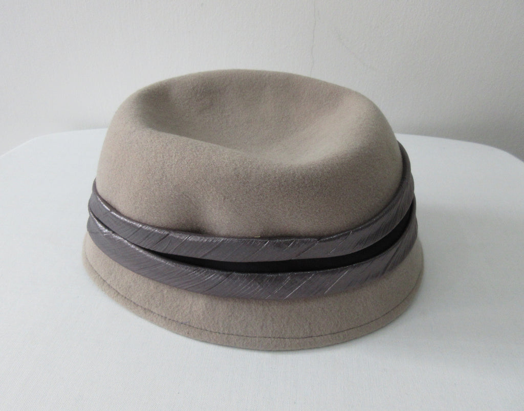 Olka Taupe Hat taupe colour felt with grey/black wrap around sash trim on brim. Size unknown, 57.5cm circumference. Height 12.5cm, Length 26.5cm, width 16.5cm. 26g approximate weight. 100% Wool. Made in Canada.