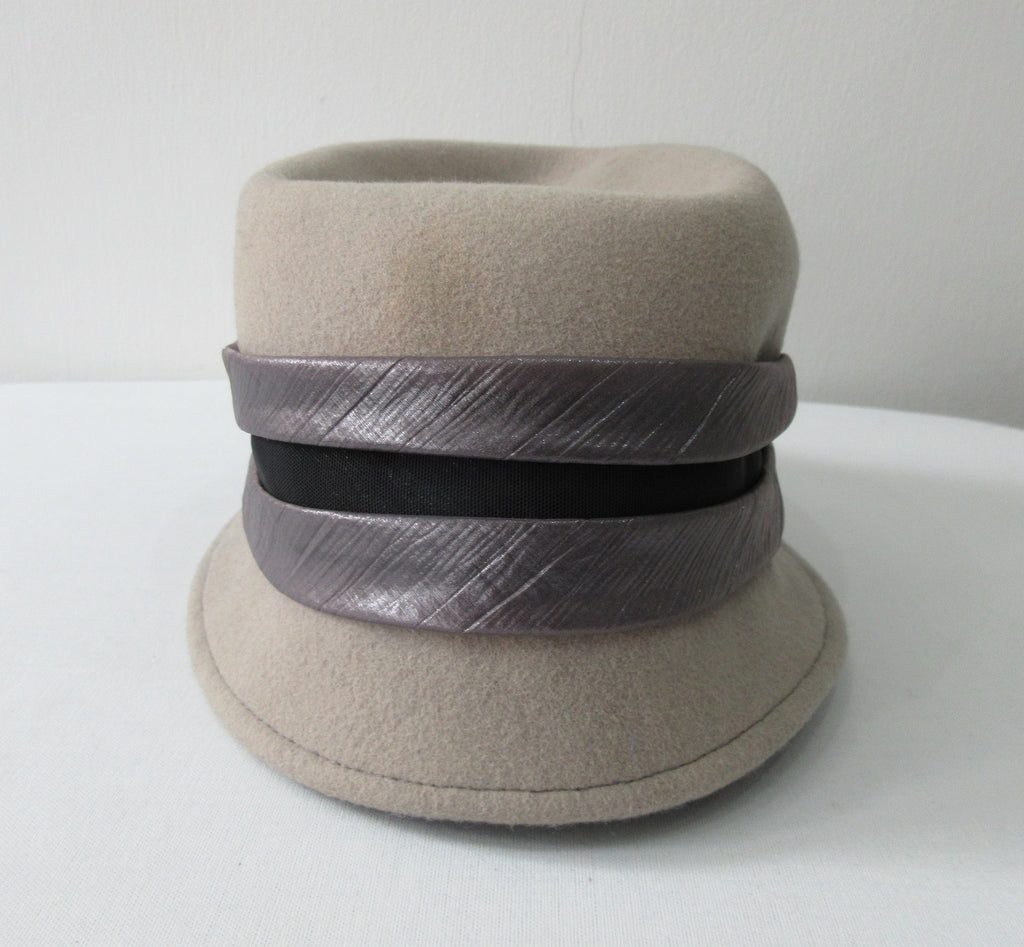 Olka Taupe Hat taupe colour felt with grey/black wrap around sash trim on brim. Size unknown, 57.5cm circumference. Height 12.5cm, Length 26.5cm, width 16.5cm. 26g approximate weight. 100% Wool. Made in Canada.