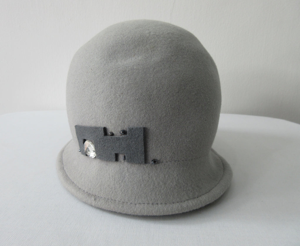 Olka Hats 100% Wool with dark grey felt and Sequin trim. Size unknown, 58.5cm inside circumfrence. Length 26.5cm, Width 20cm, Height 12cm, 26g approximate weight. 100% Wool Made in Canada