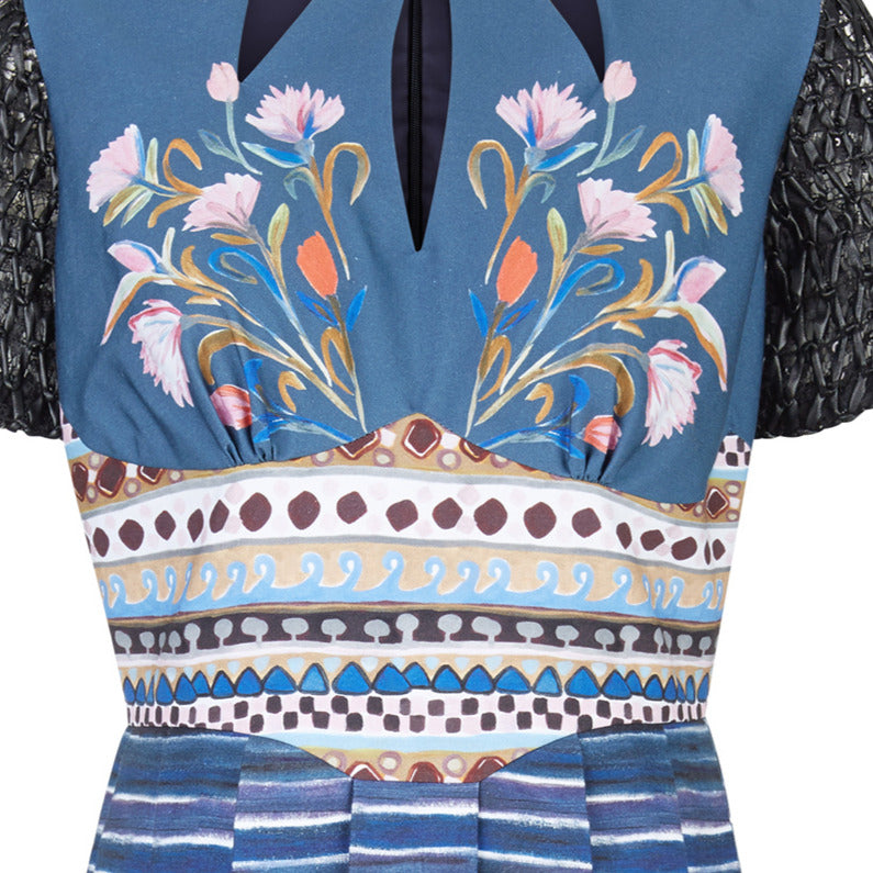 Sample sold as-is. Mid-length dress in full desert inspired print. Tri-point neck design with drawstring. Full pleats below waist panel. Contrast black faux leather textured sleeves. CB invisible zipper. 700g approximate weight. 100% Polyester. Contrast: 100% Cotton Dry Clean Only. Made in England