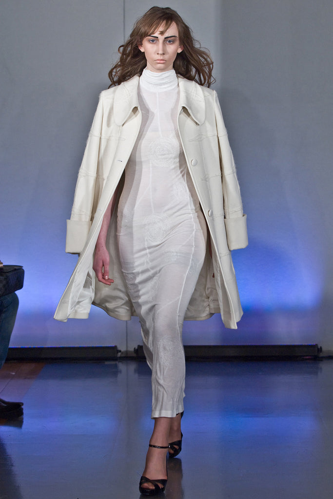 Generously cut 3/4 length coat with large rounded collar and covered buttons in off white, with a slight military feel. Features neo-classical trim design which naturally becomes fuzzy over time as a design detail. Size 12