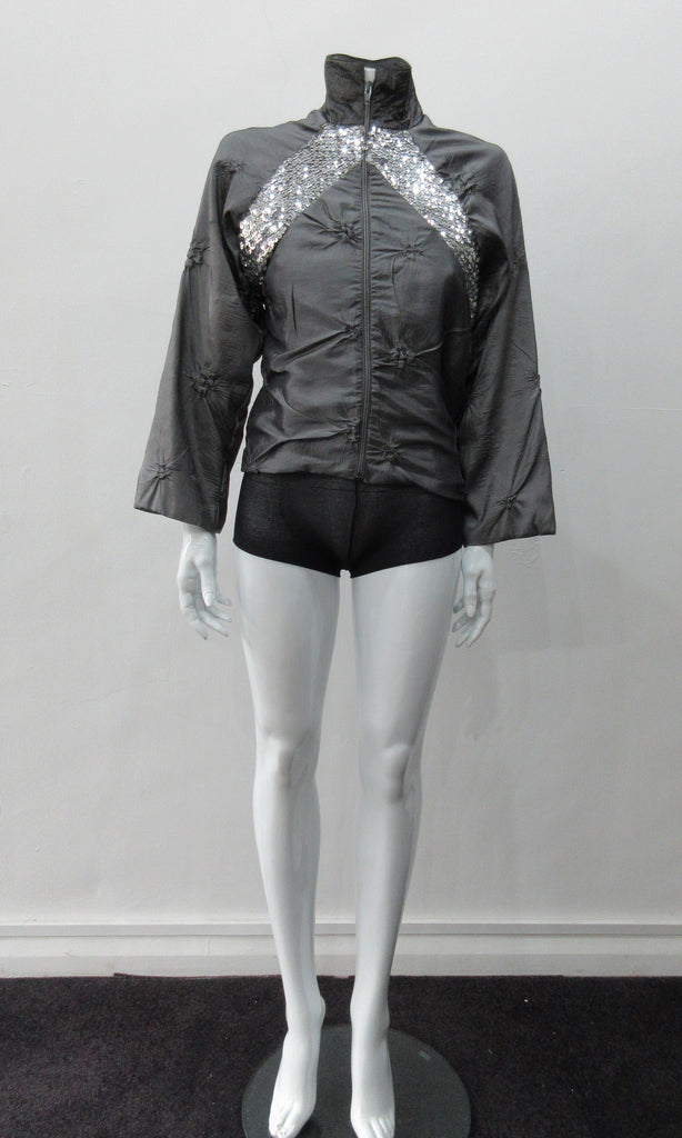 Grey Sparkle Raglan Panel Zip Jacket. Featuring pinched satin fabric and brilliant sequin panel on both front and back sides. CF zipper and 8cm high contrast collar. CB length 56cm. Sleeve length from side neck point 66cm. 220g approximate weight. 60% Polyester, 30% Viscose, 10% Nylon. Lining: 100% Rayon. Dry Clean Only. Made in Canada