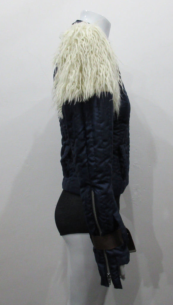 Navy blue padded jacket with striped stitching. Featuring faux Mongolian fur around sleeve caps. Big belted buckles on sleeve hems. CF industrial metal zipper. Size 8