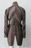 Brown Wave Cut Away Coat. Mid 19th Century military style cut-away coat in textured array of brown & brass. Slight reptile print covered with sheer stripe fabric pieces. CF cutaway and 29cm. CB slpit open back vent at hem. 2 button closure. CB length from neck point 91cm. Sleeve length from side neck point 80cm. 700g approximate weight. 75% Polyester, 25% Nylon Lining: 100% Rayon. Dry Clean Only. Made in Canada