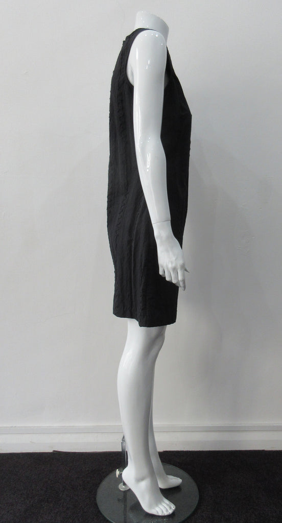 Black Flap Shoulder Dress. The ideal little black sleevelss dress featuring assymetric styling with piping. CB invisible zipper. Fully lined. Size 8