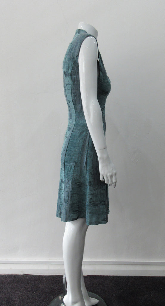 Round Seam Dress. Dark sea green textured dress with curved neck panels. With CB zipper. CB length 93cm. 82% Wool, 18% Nylon. Lining: 100% Rayon. Dry Clean Only, Made in Croatia
