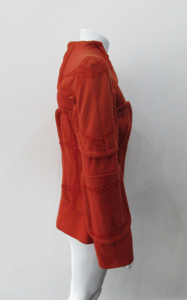 Trench Panel style Jacket in Deep Carrot Orange colour.  Panel design on shoulders and side waist in Deep Carrot Orange colour. Geoetric thread design becomes more fuzzy with aging, natural process and part of the design. CF zipper. 65cm approximate length. 600g approximate weight. Size 6, 80% Wool, 20% Nylon Lining: 100% Rayon Dry Clean Only. Made in Croatia