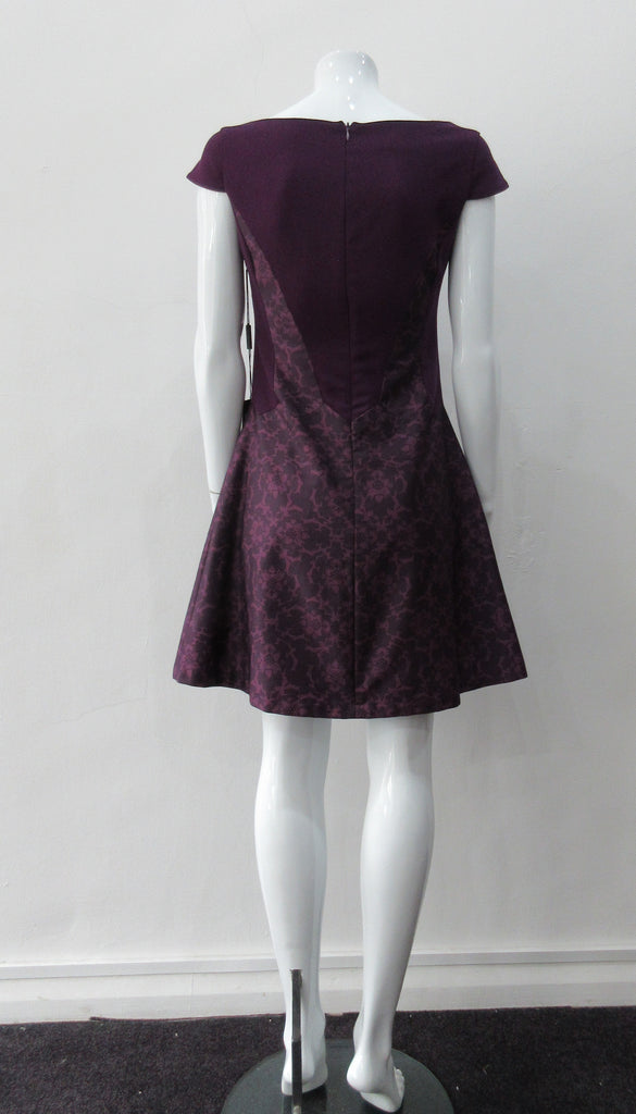 Pointed Tip Dress. Rich purple wool dress with matching floral book print contrast panels and base. Soft cap sleeve top and CB zipper. CB Length 82cm. 550g approximate weight. 100% Wool. Contrast: 100% Cotton, Lining: 100% Rayon. Dry Clean Only, Made in England