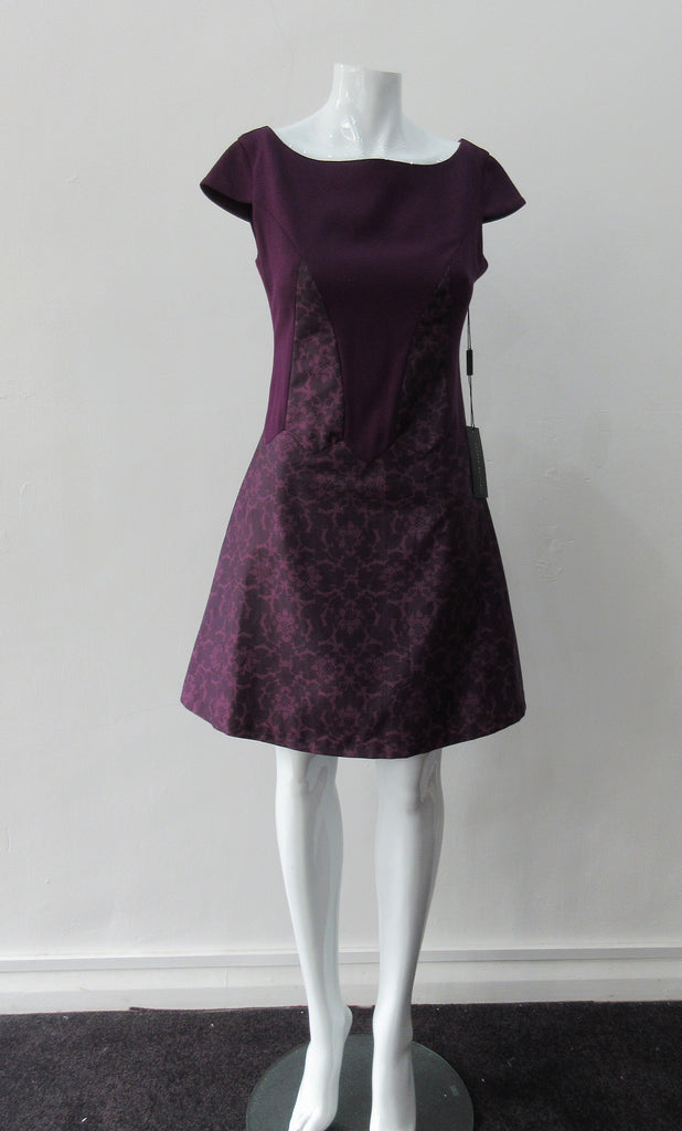 Pointed Tip Dress. Rich purple wool dress with matching floral book print contrast panels and base. Soft cap sleeve top and CB zipper. CB Length 82cm. 550g approximate weight. 100% Wool. Contrast: 100% Cotton, Lining: 100% Rayon. Dry Clean Only, Made in England