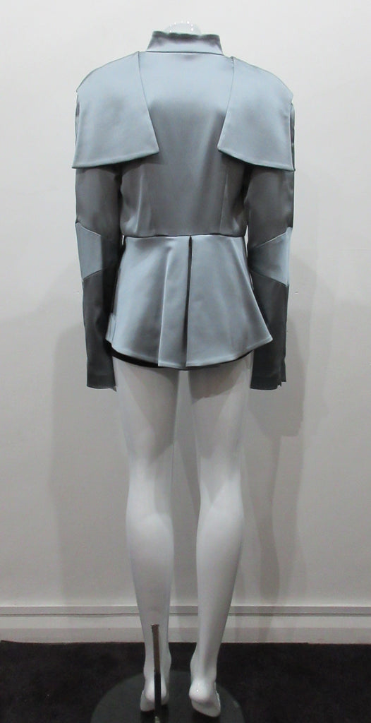 Grey-Blue flap panel short jacket, with pleated peplum. Heavier weight fabric ideal for colder weather wear. CF and sleeve hem zippers.