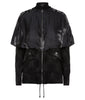 Black cropped jacket with shiny satin cape over shoulders in a relaxed fit. Geometric weave on fabric in black colour. Faux leather trim and toggle waist. CF metal zipper. 450g approximate weight. 64% Wool, 36% Silk. Contrast: 100% Nylon. Dry Clean Only. Made in England