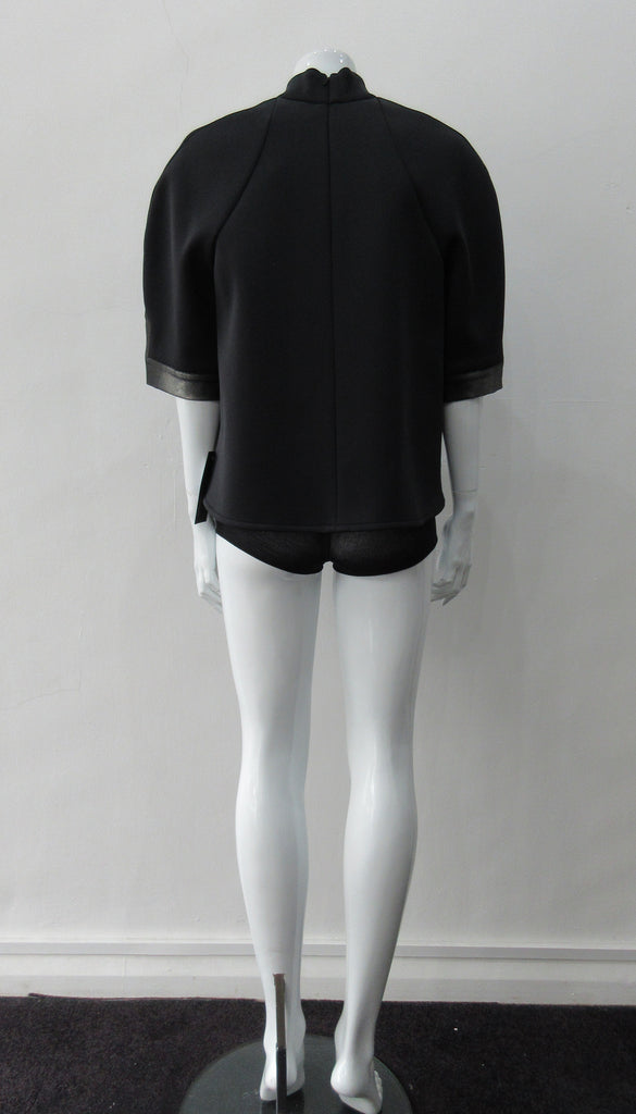 Black Crop Top. Cropped raglan sleeve top in medium weight scuba with contast charcoal colour, shiny fabric front.  Medium sleeves with charcoal shiny contrast trim on sleeve hems.  5cm high collar. CB invisible zipper. CB neck point length 57cm 350g approximate weight.  85% Polyamide, 15% Elastine. Contrast: 98% Nylon, 2% Lycra. Dry Clean Only. Made in England