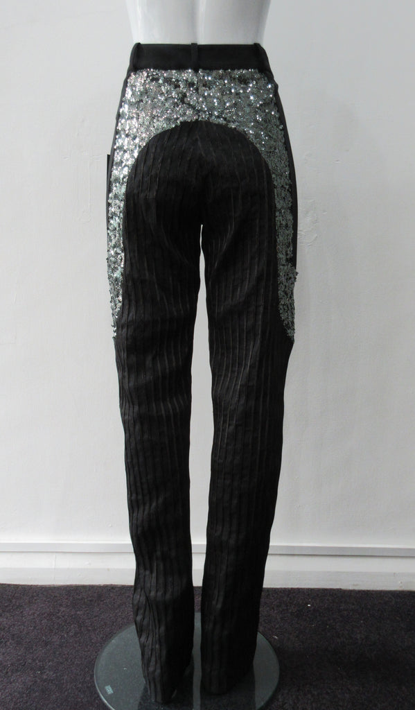 Stretch Sparkle Trouser. Black semi-tailored trouser in combination of stretch stripe & scuba with bold sequin paneling on side hips. CF invisible zipper, no side pockets. Inseam 90cm, Outseam 115cm. 400g approximate weight. 40% Polyamide, 29% Linen, 26% Polyester, 5% Elastine. Contrast: 100% Polyamide. Lining: 100% Viscose. Dry Clean Only. Made in England