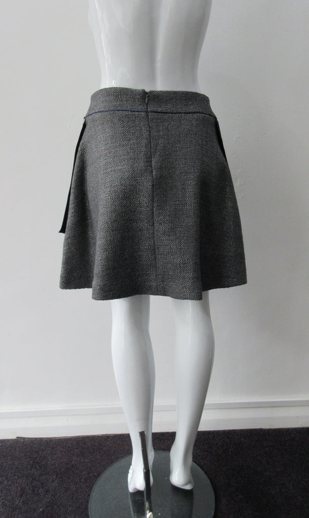 Piped Pocket Skirt. Medium length medium grey wool blend A-line skirt with slight swing. Blue piping and sport trim on sides. Side pockets included. CB zipper; CB length 46cm. 700g approximate weight. 51% Acrylic, 42% Wool, 4% Nylon, 2% Polyeurethane Lining: 100% Rayon Dry Clean Only. Made in Canada