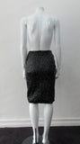 Shiny Ruched Skirt. PVC style curved linear ruching technique creating textured stretch in black. CB invisible zipper and stretch lining. Good for fetish wear. CB length 58cm. 250g approximate weight 90% Polyeurethane, 10% Cotton. Lining: 100% Viscose. Dry Clean Only. Made in Canada