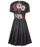 Upper floral tri-point neckline dress in 3/4 length, featuring pleated lower part of dress below waist in black satin. Contrast black faux leather textured mesh sleeves. CB zipper and contrast string around neckline. 450g approximate weight. 41% Polyester, 26% Acrylic, 7% Polyamide. Dry Clean Only. Made in England